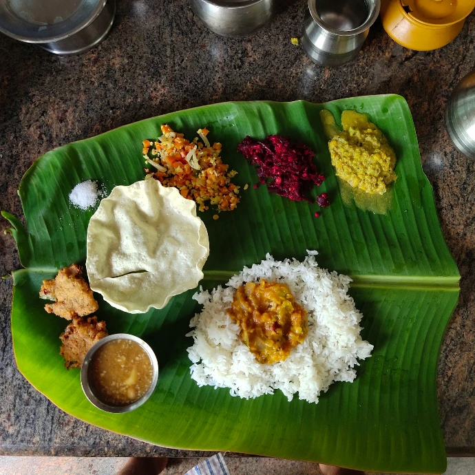A traditional South Indian meal served on a large green banana leaf
